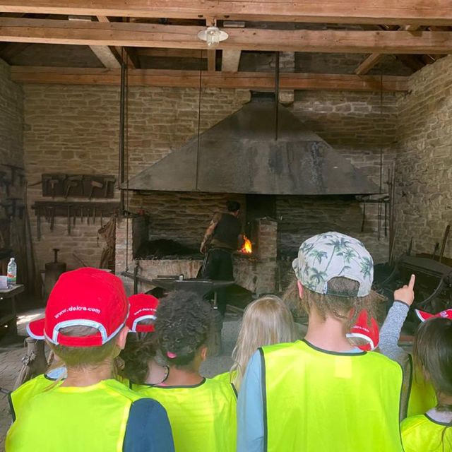 Kinder in Warnwesten beobachten einen Ofen.