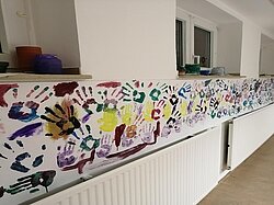 Eine weitere Ansicht derselben Wand mit verschiedenen Handabdrücken und Designs.