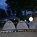 Mehrere Zelte im Freien bei Nacht aufgebaut.