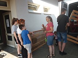 Eine Gruppe Leute bewegt Möbel zu einem geöffneten Lieferwagen