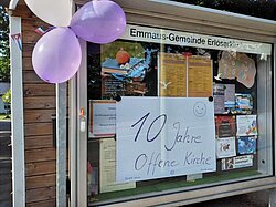 Schwarzes Brett kündigt „10 Jahre Offene Kirche“ mit Luftballons an.