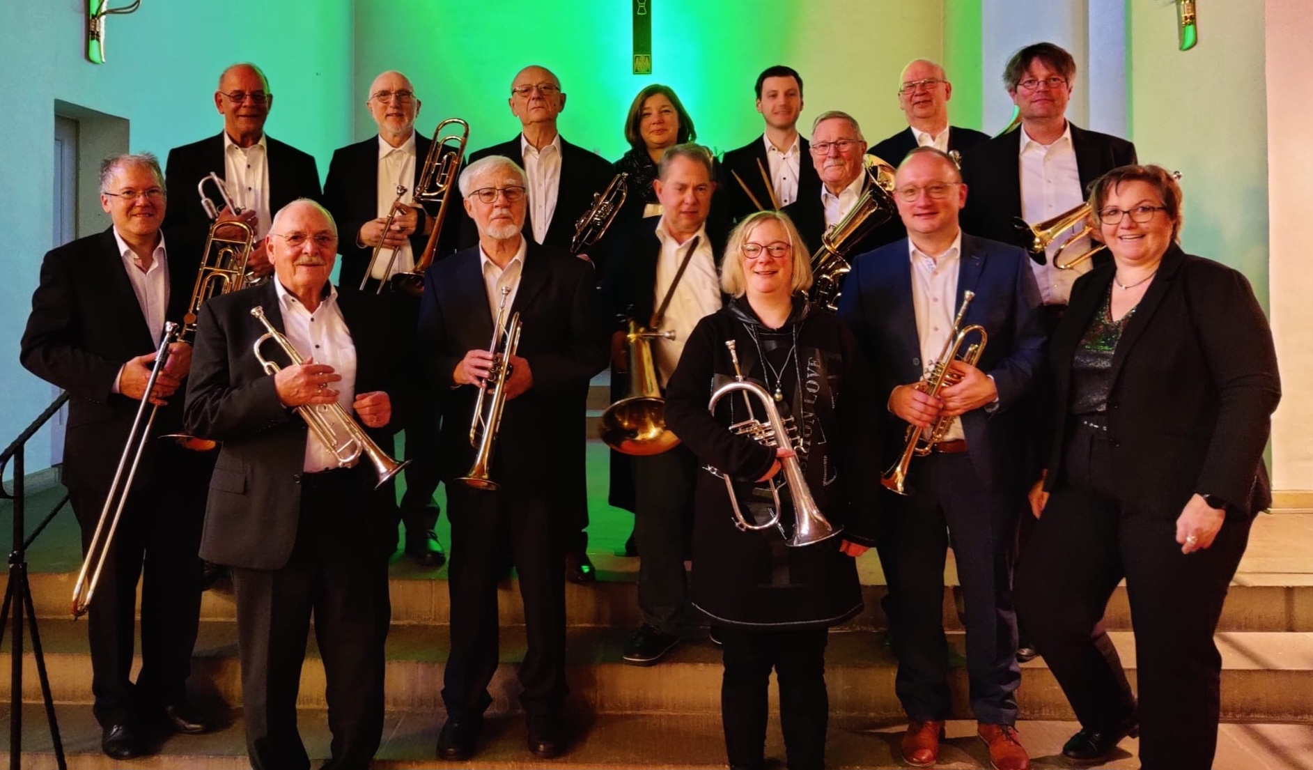 Gruppe von Musikern posiert mit Blechblasinstrumenten.