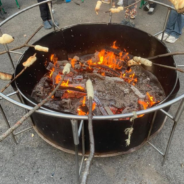 Spieße mit Brot über offenem Feuer.