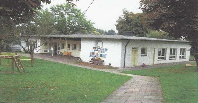 Kindergartengebäude mit grünem Rasen.