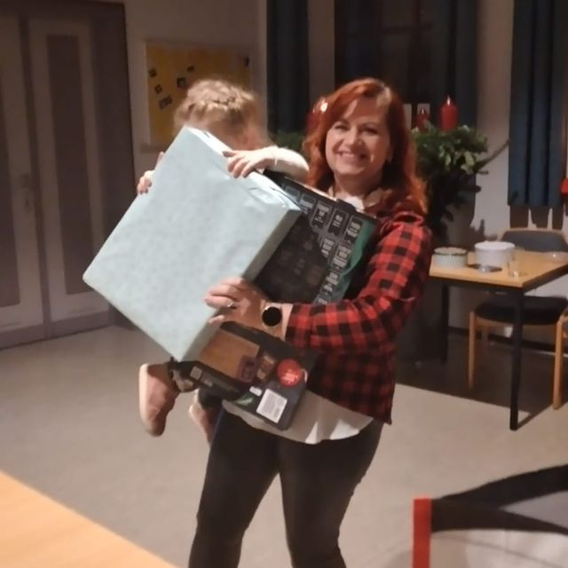 Eine Frau hält ein verpacktes Geschenk.