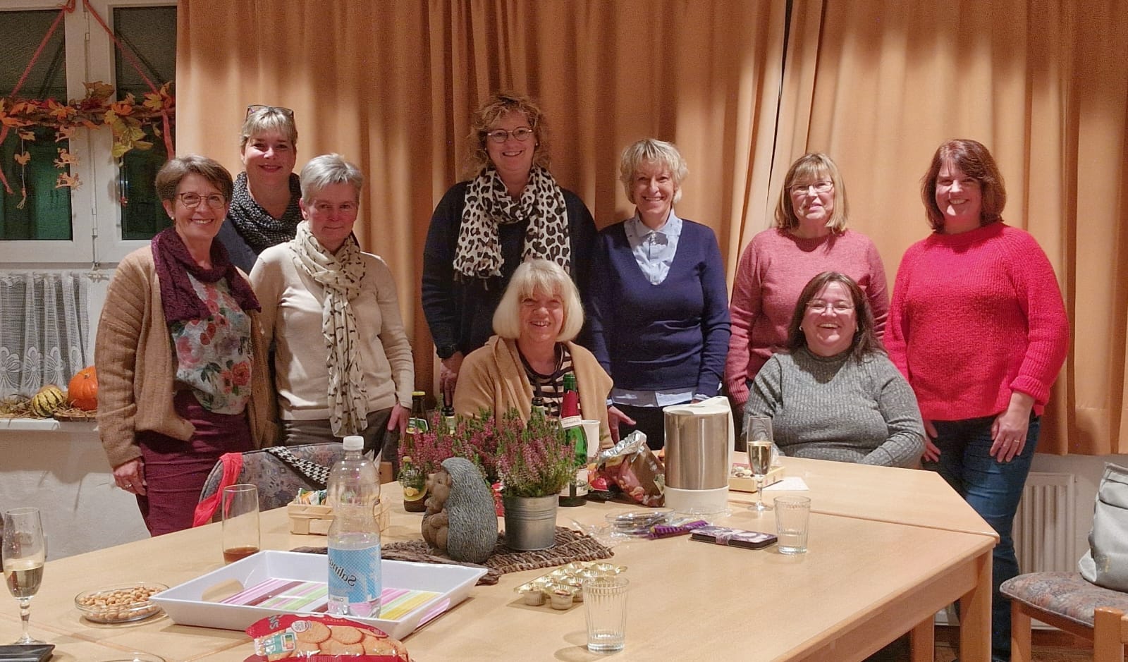 Gruppe von Frauen versammelt sich an einem Tisch zu einer Feier.